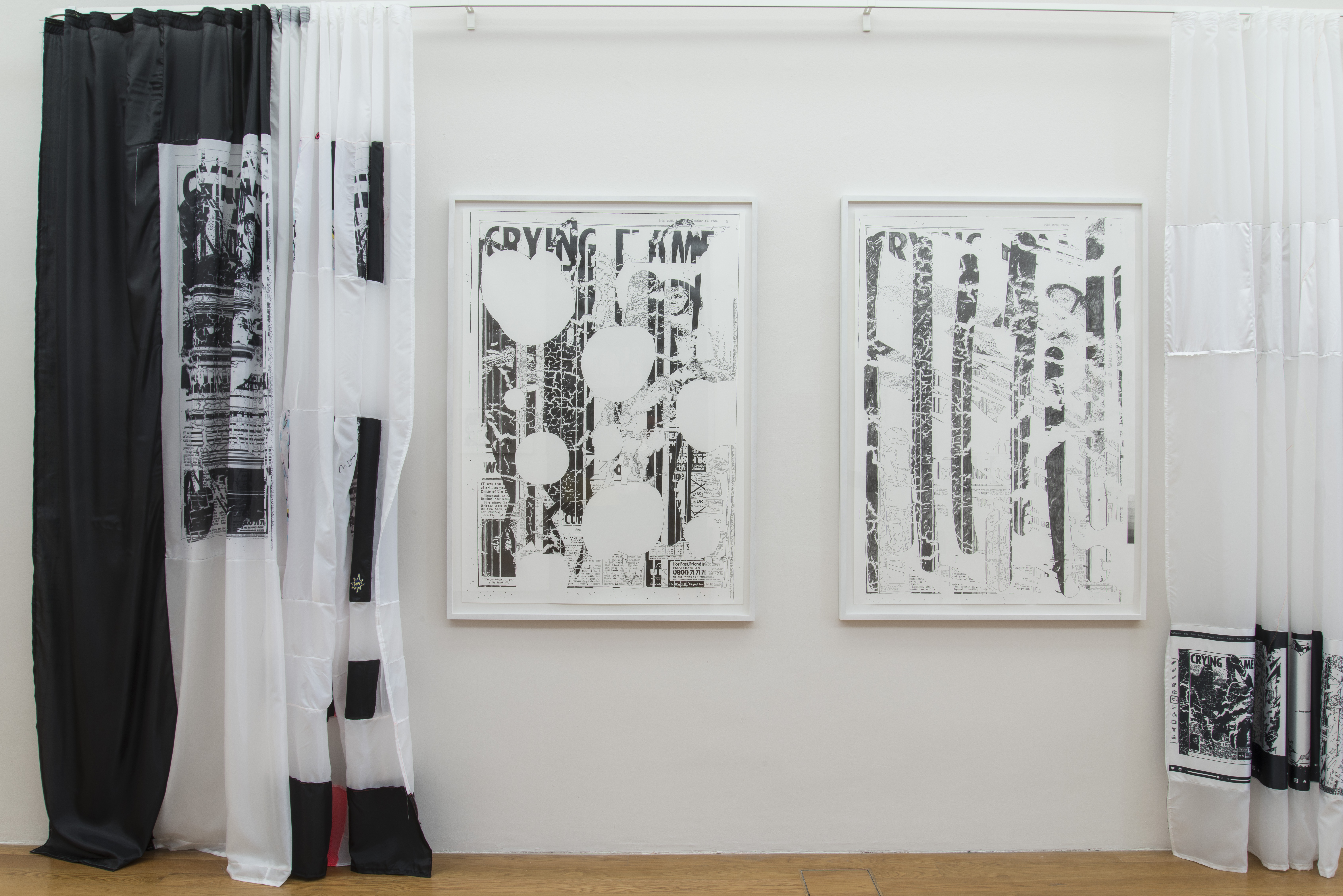 KI generiert: Die Hauptinhalte des Bildes sind zwei gerahmte, teilweise abstrakte Kunstwerke an einer weißen Wand, die von bedruckten schwarzen und weißen Vorhängen flankiert werden. Die Kunstwerke scheinen Collagen mit grafischen Elementen und teilweise unkenntlichen Texten zu sein.