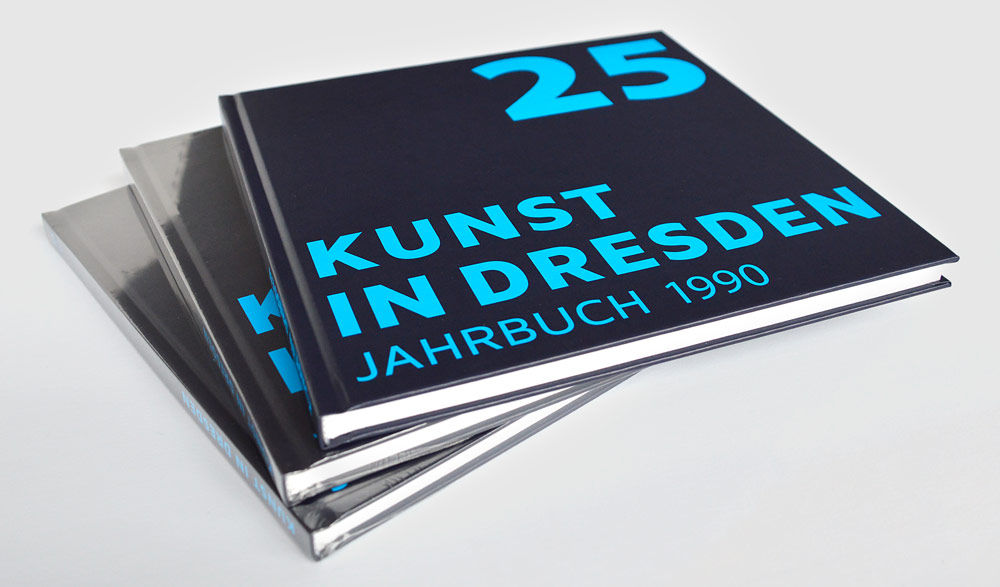 KI generiert: Das Bild zeigt einen Stapel von Jahrbüchern mit dem Titel "Kunst in Dresden," wobei das oberste Buch die Ausgabe von 1990 und die Zahl 25 auf dem Einband zeigt. Der Hauptinhalt des Bildes sind die gestapelten Jahrbücher.