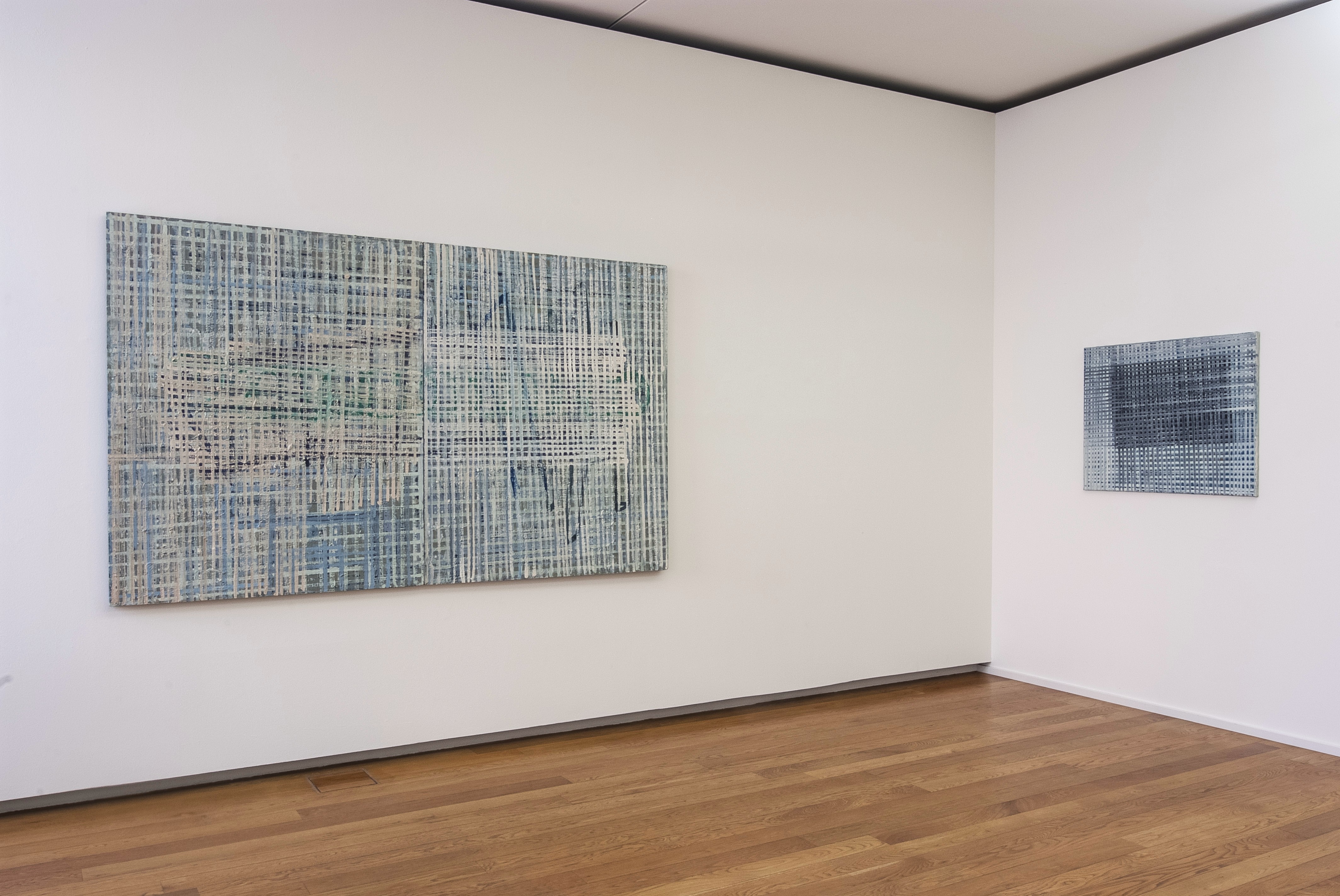 AI generated: The image shows a gallery with two abstract artworks on a white wall consisting of blue, net-like patterns. The room has a wooden floor that complements the artworks.
