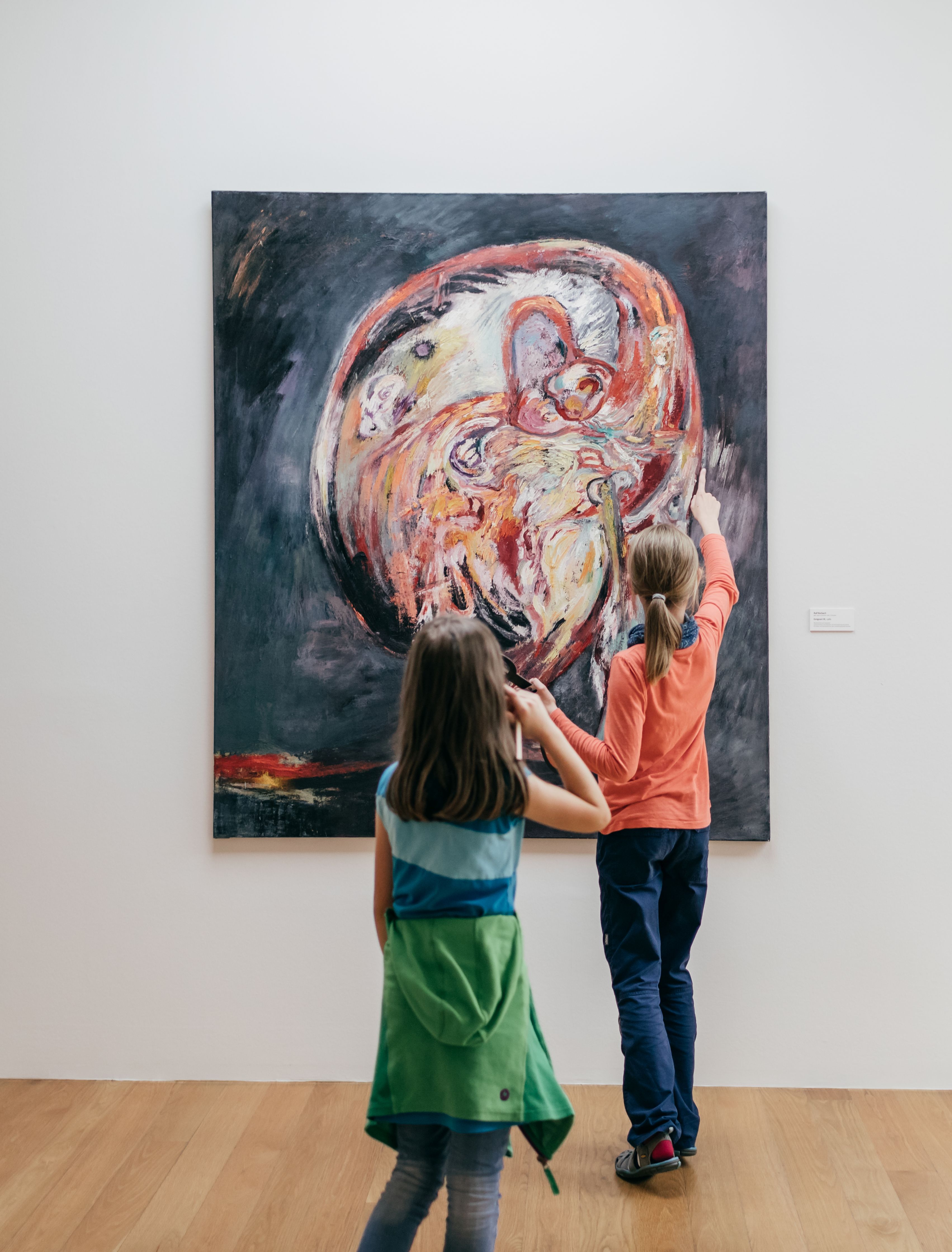 KI generiert: Das Bild zeigt zwei Kinder, die ein großes Gemälde in einem Museum betrachten. Eines der Kinder zeigt interessiert mit dem Finger auf das Kunstwerk.