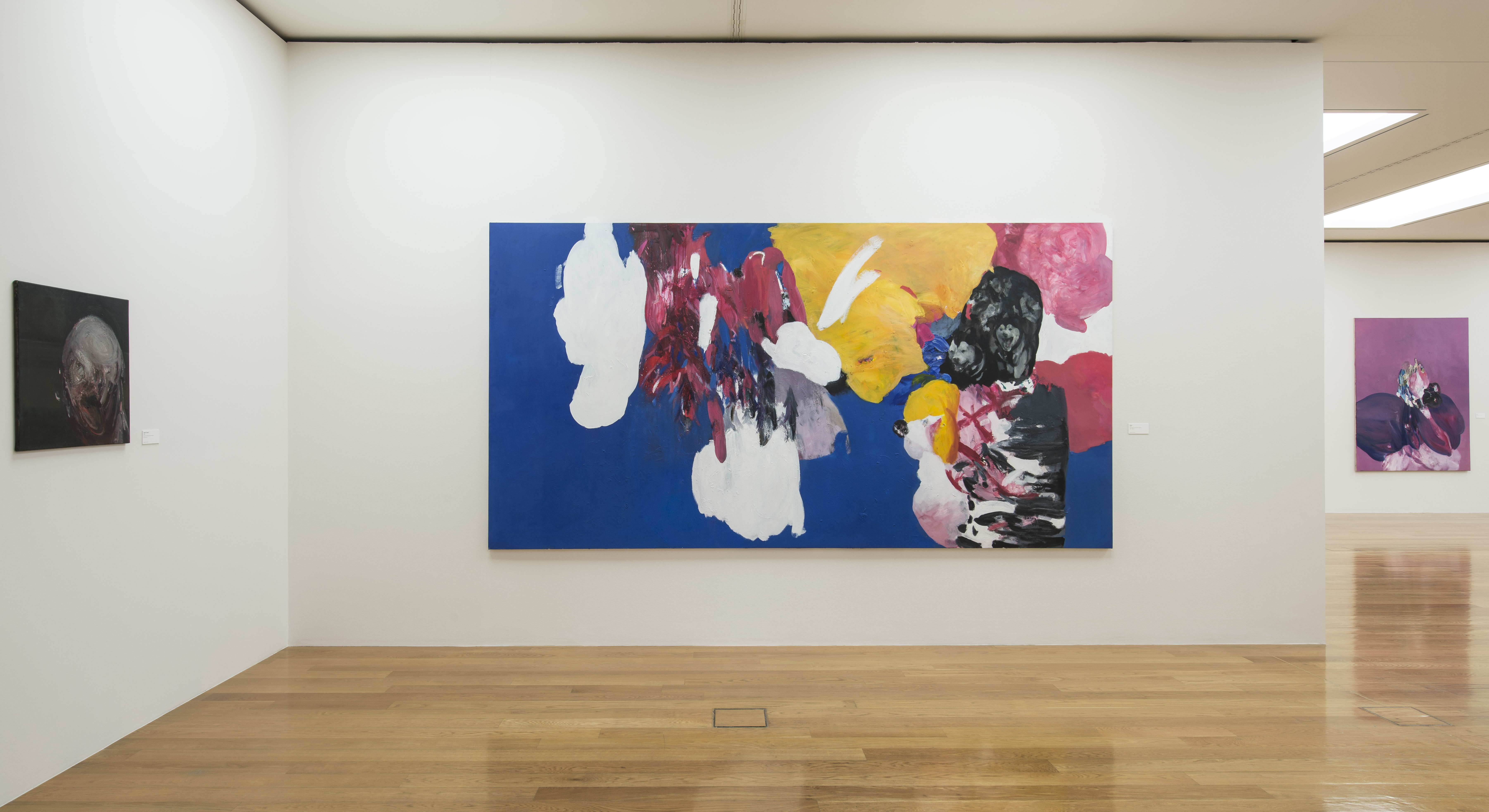 KI generiert: Das Bild zeigt eine moderne Kunstausstellung mit abstrakten Gemälden, die leuchtende Farben und verschiedene Formen auf weißen Wänden präsentieren. Der Hauptinhalt sind die großflächigen Kunstwerke, die durch ihre kräftige Farbgebung und dynamische Gestaltung hervorstechen.