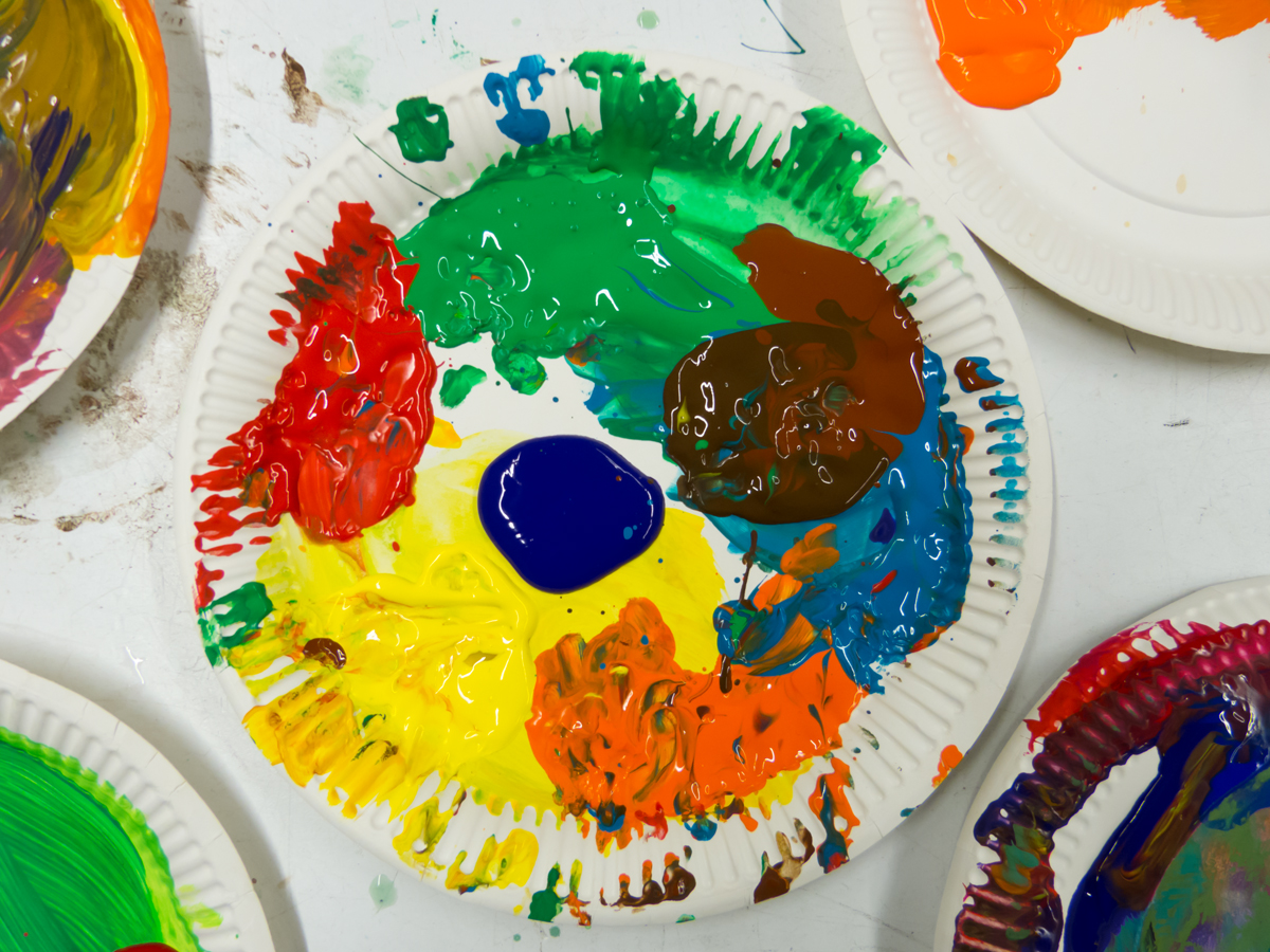 KI generiert: Das Bild zeigt eine Papierplatte, die mit verschiedenen Farben bemalt ist. Es handelt sich um eine Palette mit Farbmischungen, die möglicherweise für ein Kunstprojekt verwendet wird.