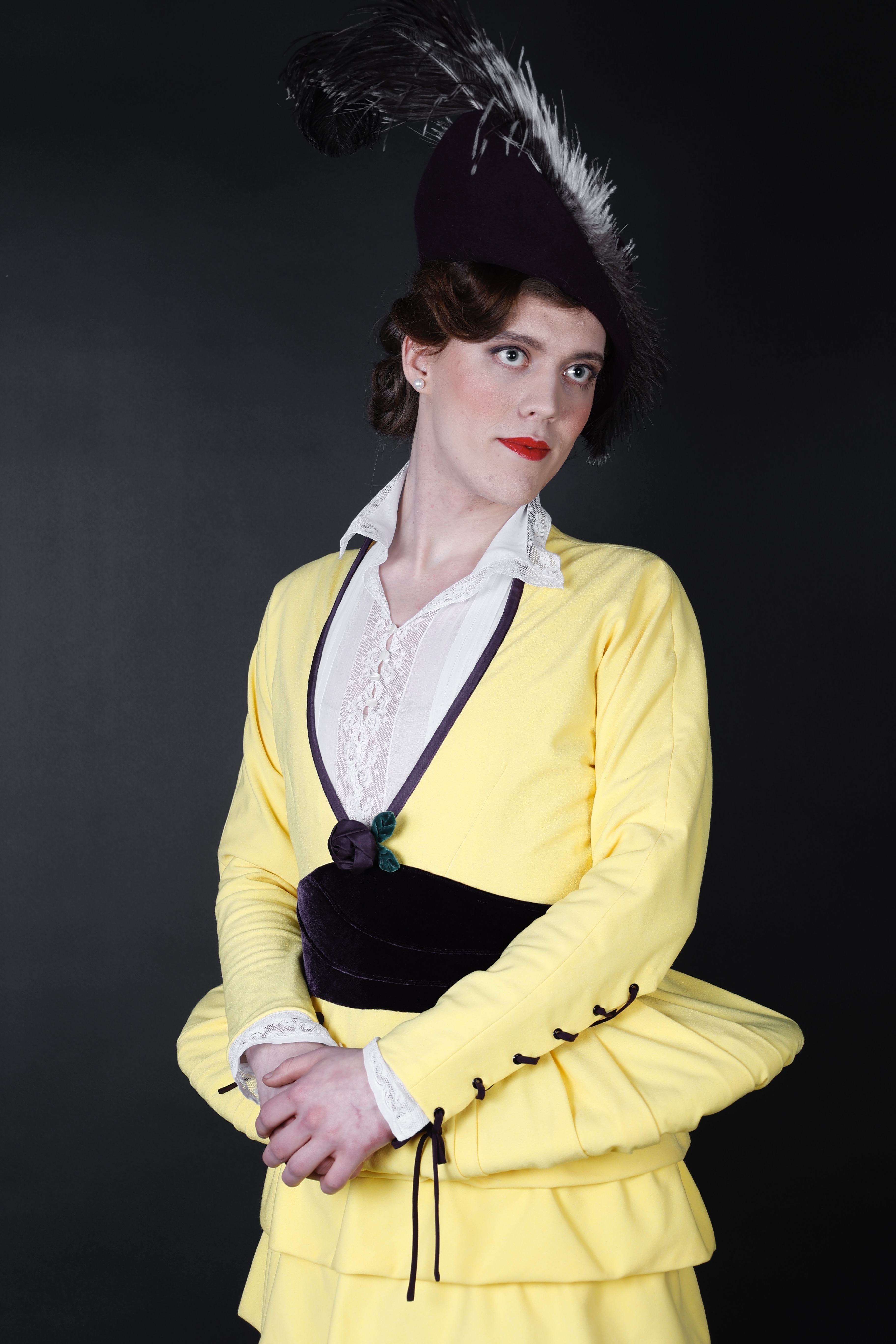 KI generiert: Das Bild zeigt eine Person in einem stilvollen, historischen Kostüm mit einem gelben Kleid und einem auffälligen Federhut. Der Fokus liegt auf der eleganten Pose und der Kleidung der Person.