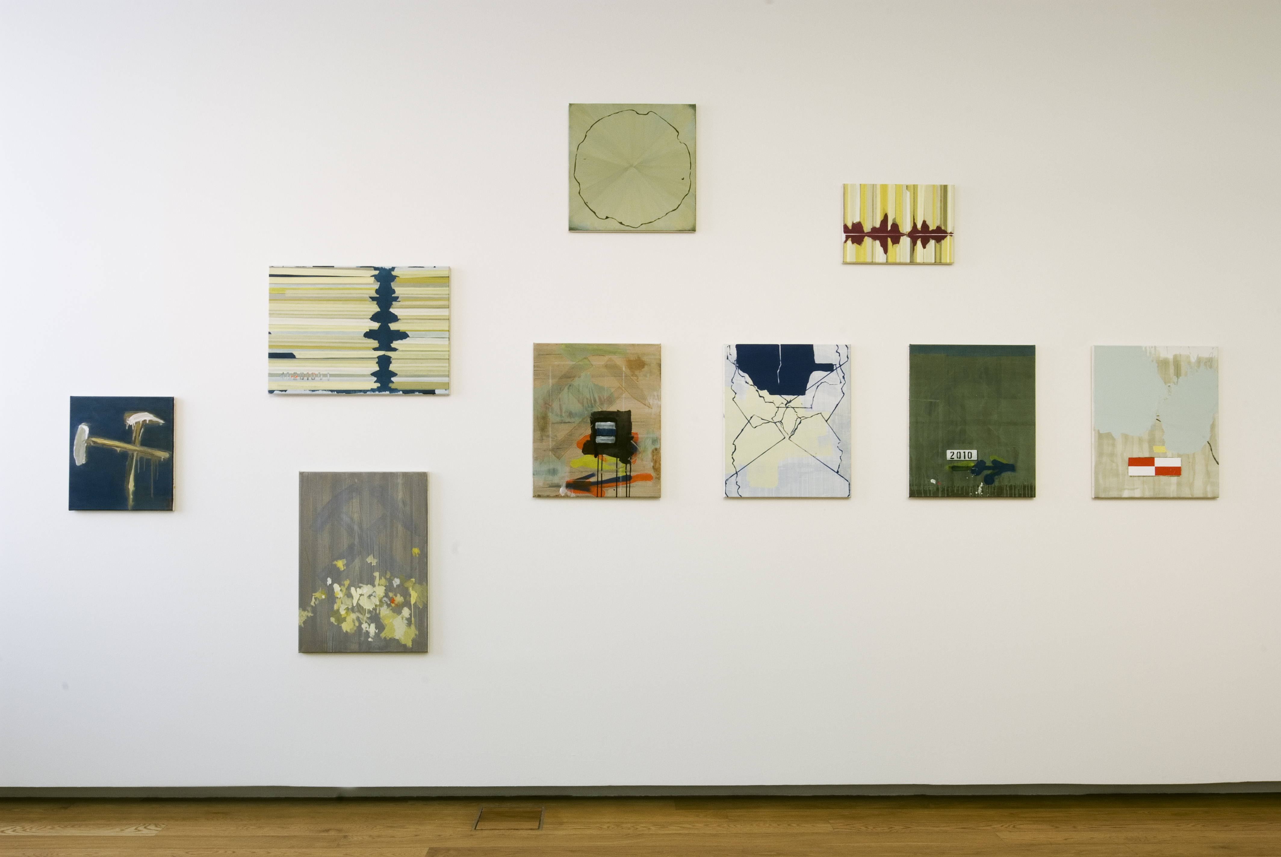 KI generiert: Das Bild zeigt eine Ausstellung von mehreren abstrakten Gemälden, die an einer weißen Wand hängen. Die Kunstwerke variieren in Farbe und Komposition und verleihen der Präsentation eine vielfältige Ästhetik.