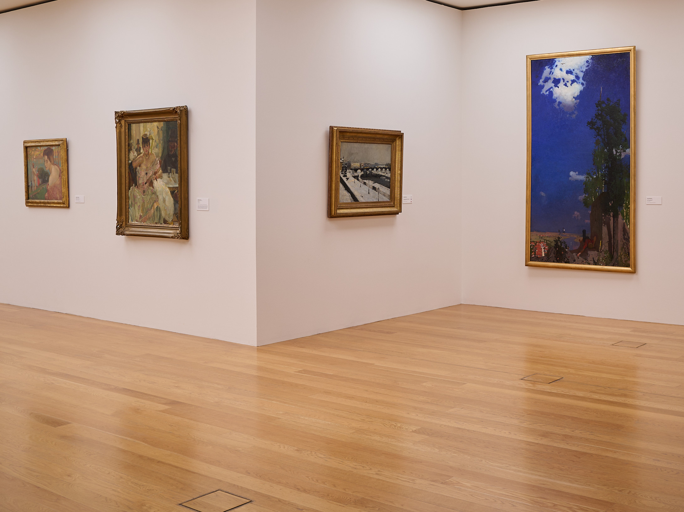 KI generiert: Das Bild zeigt eine Kunstgalerie mit mehreren Gemälden an weißen Wänden, beleuchtet durch Oberlichter. Der Raum hat einen hölzernen Boden und eine ruhige, minimalistische Atmosphäre.
