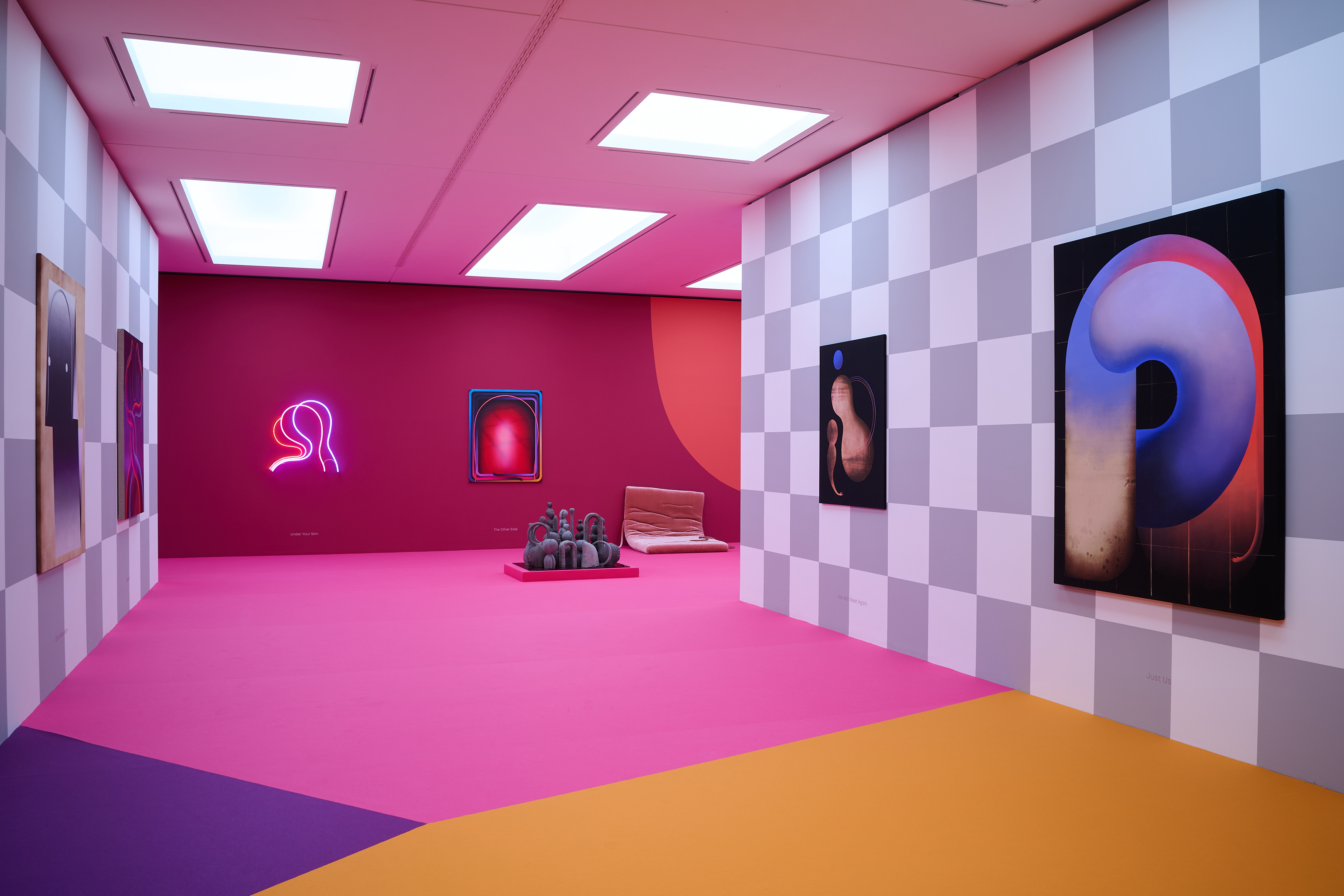 AI generated: The image shows a modern art gallery space with colourful walls and geometric patterns, in which abstract paintings and sculptures are displayed. The dominant colours are pink and purple, complemented by bright lighting from the ceiling.